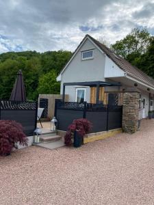 a white house with a black fence and a patio at Pen-Y-Worlod Cottages in Abergavenny