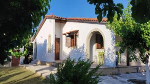 a white house with a red roof at Dyada Home in Nea Stira