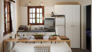 a kitchen with a table and a white refrigerator at Dyada Home in Nea Stira