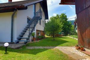 a house with a blue staircase on the side of it at Sava river house - apartments in Bled