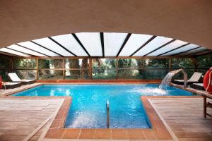a swimming pool with a waterfall in a house at Rigat Park & Spa Hotel in Lloret de Mar