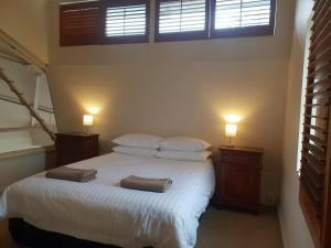 a bedroom with a white bed with two towels on it at Granita's - 2 bedroom converted South Fremantle warehouse apartment in Fremantle