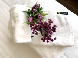 a bouquet of purple flowers on a white towel at C Hotel Boutique and Comfort in Chiang Mai