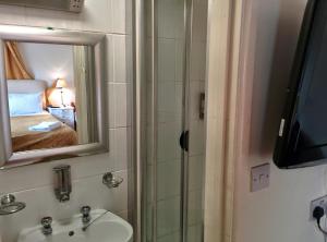 un bagno con lavandino e specchio di Acorn Guest House a Cambridge Altre 32 foto