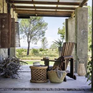 un patio con una silla, una mesa y cestas en Twyfelberg Karoo Hideaway, en Britstown