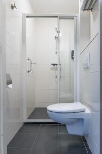 ein Bad mit einem WC und einer Glasdusche in der Unterkunft Hotel Millingen in Millingen am Rhein