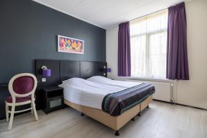 - une chambre avec un lit, un bureau et une chaise dans l'établissement Hotel Millingen, à Millingen-sur-Rhin