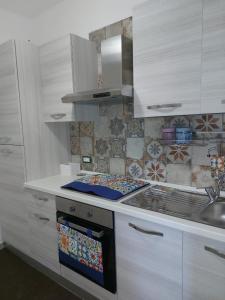a kitchen with white cabinets and a stove top oven at B&B CasaCaselle in Caselle in Pittari
