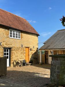 a brick house with a table and chairs in front of it at The Groom's Cottage in Towcester