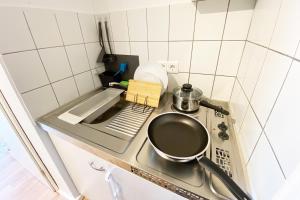 a small kitchen with a pot on a stove at Business & Tourist Apartment with Balcony in Osnabrück