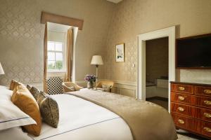 a bedroom with a large bed and a television at The K Club in Straffan