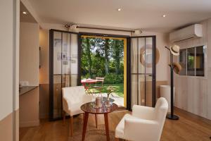 a living room with a table and chairs and a window at Salamandre et Hippocampe in Lanton