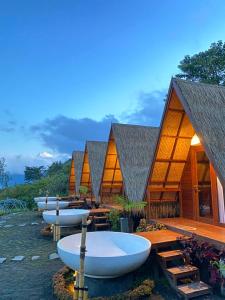 a row of cottages with white tubs in front of them at Segara Camp Kintamani in Kintamani