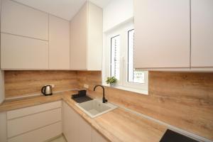 a kitchen with white cabinets and a sink at House 44 SEAFRONT APARTMENTS in Kotor