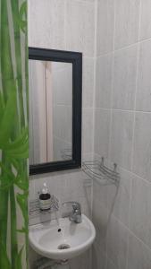 Baño blanco con lavabo y espejo en Mister Hostel en Leópolis