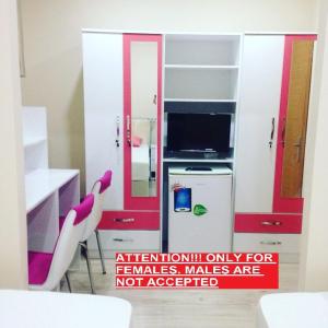 eine Küche mit roten und weißen Schränken und zwei weißen Stühlen in der Unterkunft !ONLY FEMALES! Bakirkoy Ladies Dormitory in Istanbul + 18 Fotos