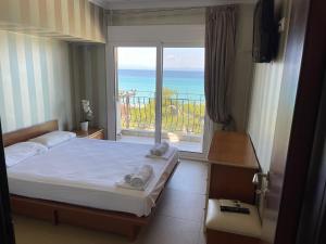 una camera da letto con un letto e vista sull'oceano di Plaza Hotel a Hanioti