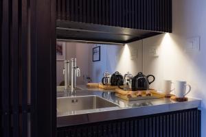 a kitchen with a sink and a counter top at La Suite West - Hyde Park in London