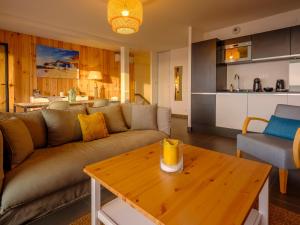 a living room with a couch and a wooden table at Résidence Les Suites Du Ferret in Cap-Ferret +17 photos