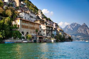 a group of buildings on a hill next to a body of water at Boutique Homes in Lugano