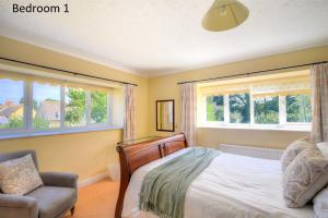 バートン・ブラッドストックにあるManor Lodgeのベッドルーム1室(ベッド1台、椅子、窓付)