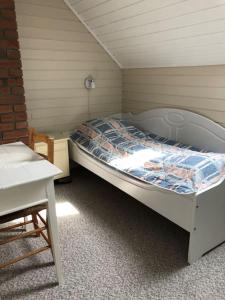 a small bedroom with a bed and a table at Holandsøya Gård 