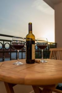 Una botella de vino y dos copas en una mesa de madera. en Luxury Apartments Ivanovic, en Tivat