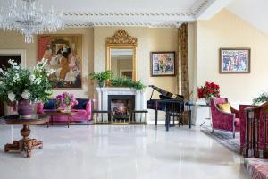 a living room with pink furniture and a piano at The K Club in Straffan