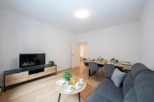 un soggiorno con divano grigio e tavolo di Boutique Homes - Happy Rentals a Lugano