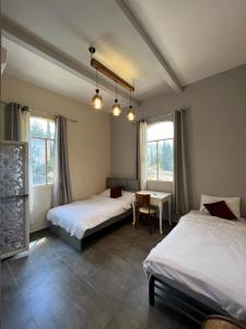 1 dormitorio con 2 camas, mesa y ventanas en Diamond Apartment In Haifa, en Haifa