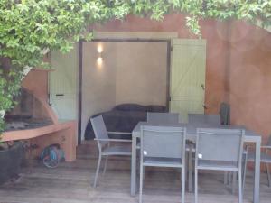 ポルト・ヴェッキオにあるRésidence Le Village Marinのソファ付きの客室で、テーブルと椅子が備わります。