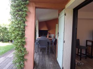uma porta aberta para um deque com uma mesa e cadeiras em Résidence Le Village Marin em Porto-Vecchio