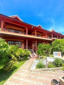 a large building with a view of the ocean at PS Thana Resort - SHA Extra Plus in Choeng Mon Beach