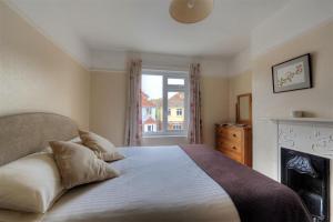 a bedroom with a bed with a fireplace and a window at 23 Lym Close in Lyme Regis