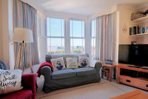 uma sala de estar com um sofá e uma televisão em 1 Cobb View em Lyme Regis