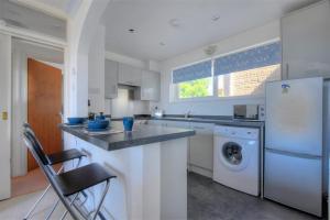 a kitchen with a refrigerator and a dishwasher at 38 Wessex Court in Lyme Regis