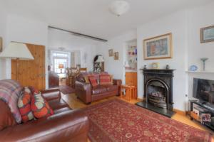 un soggiorno con divano e camino di Windwhistle a Lyme Regis
