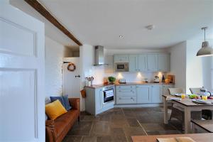 a kitchen and living room with a couch and a table at Ancient Lights in Lyme Regis