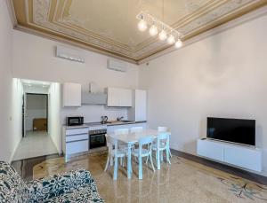 a kitchen with a table and chairs and a tv at Appartamenti in Villa del '900 (A) in Varazze