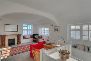 a living room with a red couch and a fireplace at 4 East Cliff in Lyme Regis