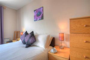 a bedroom with a bed with two pillows on it at 4 Bay View Court in Lyme Regis