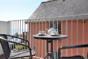 a table with a tea set on top of a balcony at 4 Bay View Court in Lyme Regis
