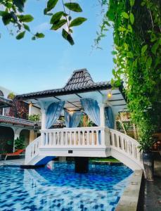 una casa con un ponte sopra una piscina di Raintree Boutique Villa & Gallery a Yogyakarta