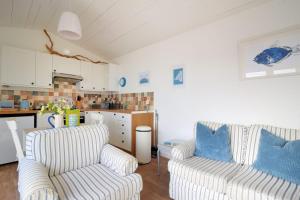 a living room with two couches and a kitchen at The Beach Hut in Lyme Regis