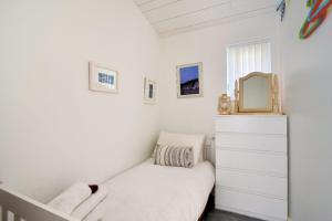 a small bedroom with a bed and a mirror at The Beach Hut in Lyme Regis