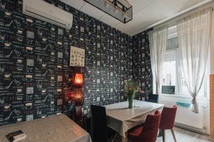 札格雷布的住宿－帕爾默斯旅舍，用餐室配有桌子和壁纸覆盖的墙面