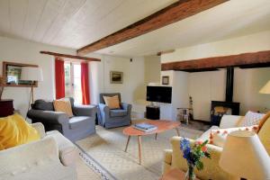 a living room with couches chairs and a tv at Church Cottage in Whitchurch Canonicorum