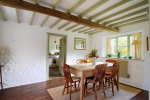 a dining room with a wooden table and chairs at Church Cottage in Whitchurch Canonicorum