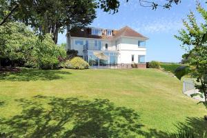 a large house on a grassy hill with a yard at Somerhill in Lyme Regis