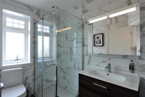a bathroom with a sink and a glass shower at Highpoint Lodge in Lyme Regis +20 photos